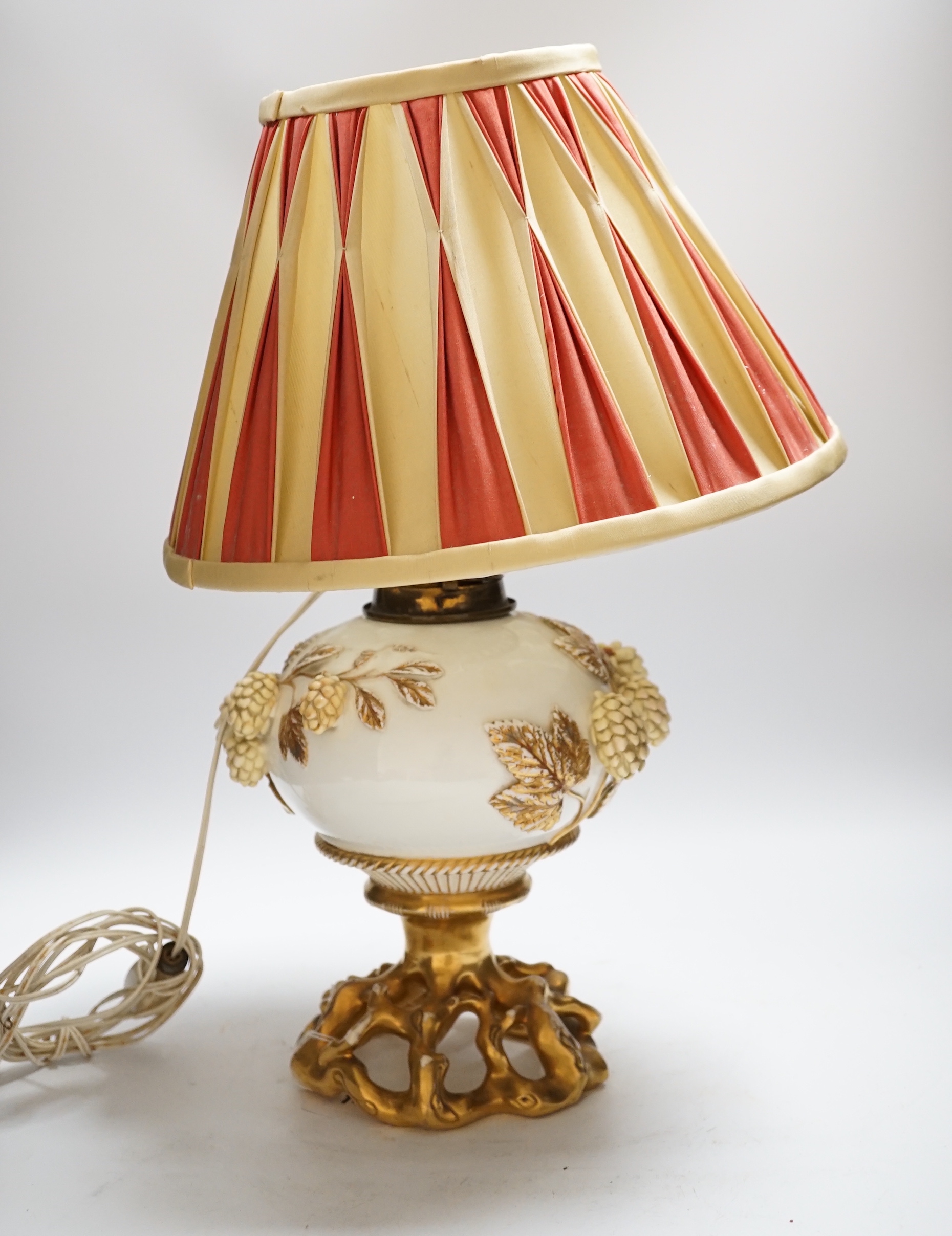 A Victorian porcelain oil lamp, probably Moore brothers, decorated with hops and gilt base, converted to electric, 45cm high